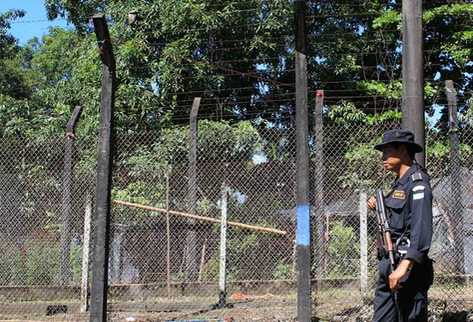 Un agente de la Policía Nacional Civil observa el área en donde supuestamente ocurrió la fuga. (Foto Prensa Libre: Enrique Paredes)