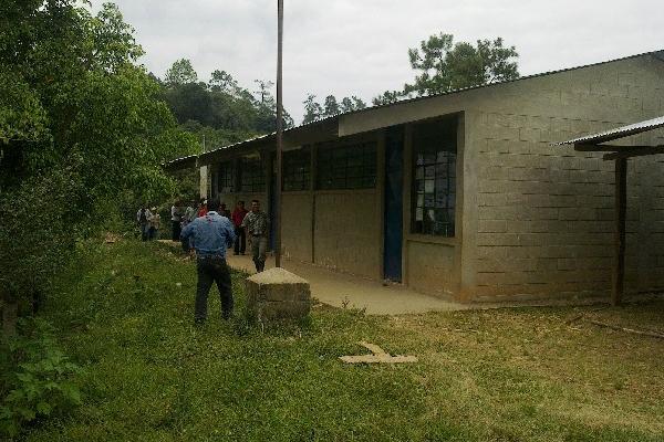 Pobladores de la aldea  La Pinada revisan los trabajos que se hicieron en el techo de la escuela.