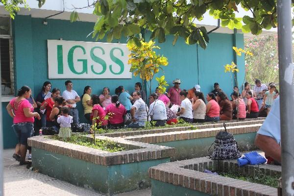 Varias personas  esperan su turno para cobrar  su boleta  en el IGSS  de Tiquisate, Escuintla.
