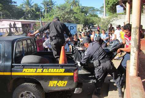 Agentes de la Policía retiran el cadáver de la tienda donde fue ultimado. (Foto Prensa Libre: Óscar González)