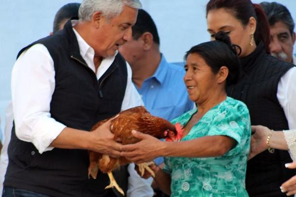 El presidente Otto Pérez Molina recibe un obsequio de una vecina de La Unión, Zacapa. (Foto Prensa Libre: Julio Vargas)<br _mce_bogus="1"/>