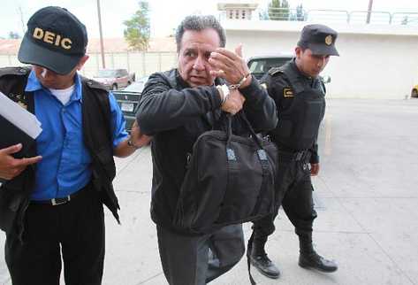 El pastor Carlos Humberto Castillo intenta   cubrirse el rostro al ser detenido, ayer.