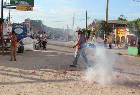 Un vecino quema cohetillos en una calle de El Chal, luego de que se enterara de que el Congreso aprobó la creación de  esa localidad  como la comuna  número 14 de Petén.