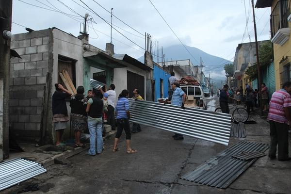 Vecinos reparan viviendas cuyos techos resultaron dañados debivo a un  ventarrón que azotó ese municipio el miércoles por la tarde. (Foto  Prensa Libre: Miguel López)