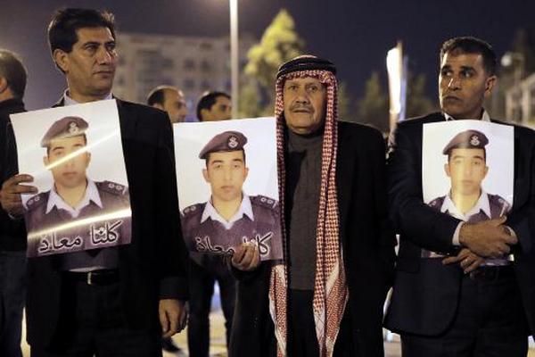 Allegados del piloto jordano Maaz al Kasasbeh se manifiestan con una imagen suya. (Foto Prensa Libre: AFP)
