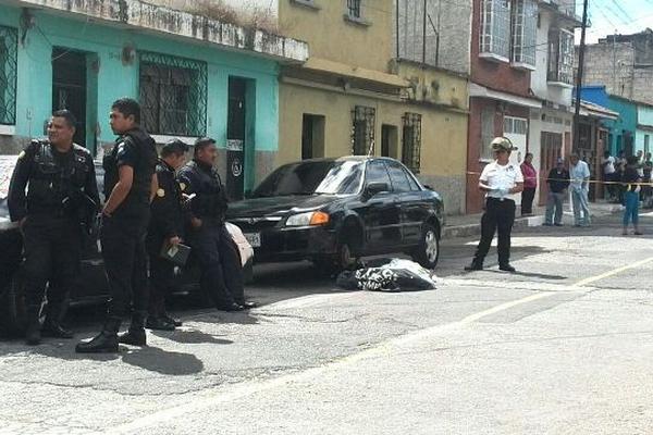 La cadáver es cubierto por un Bombero Voluntario en el barrio San Antonio, zona 6. (Foto Prensa Libre: Erick Ávila)