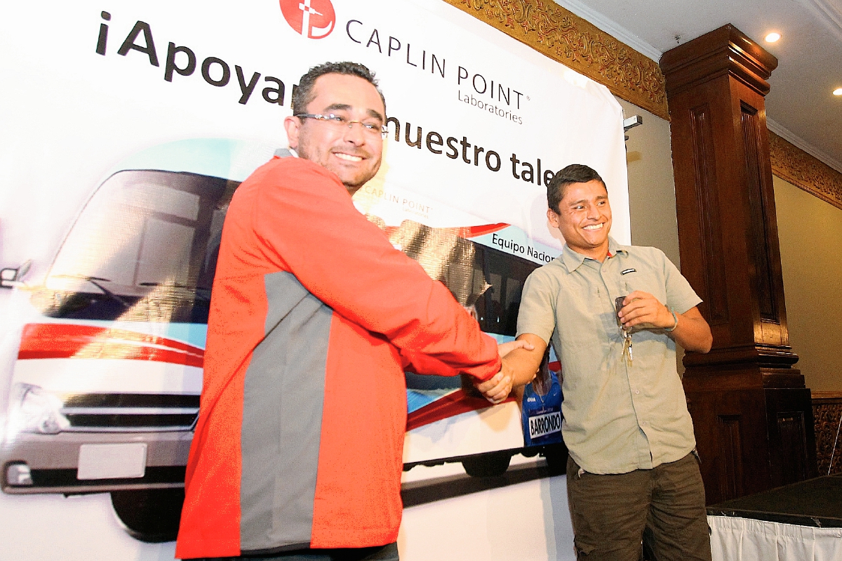 Héctor Valdez, gerente general de Caplin Point, hace entrega de la llave del bus al atleta Érick Barrondo. (Foto Prensa Libre: Allan Martínez)