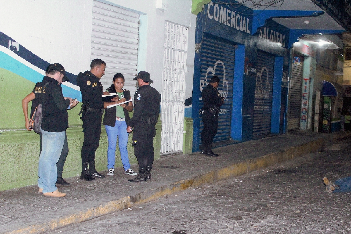 Agentes de  la PNC y fiscales del MP  examinan el área de la balacera, donde un presunto delincuente murió. (Foto Prensa Libre: Óscar González)