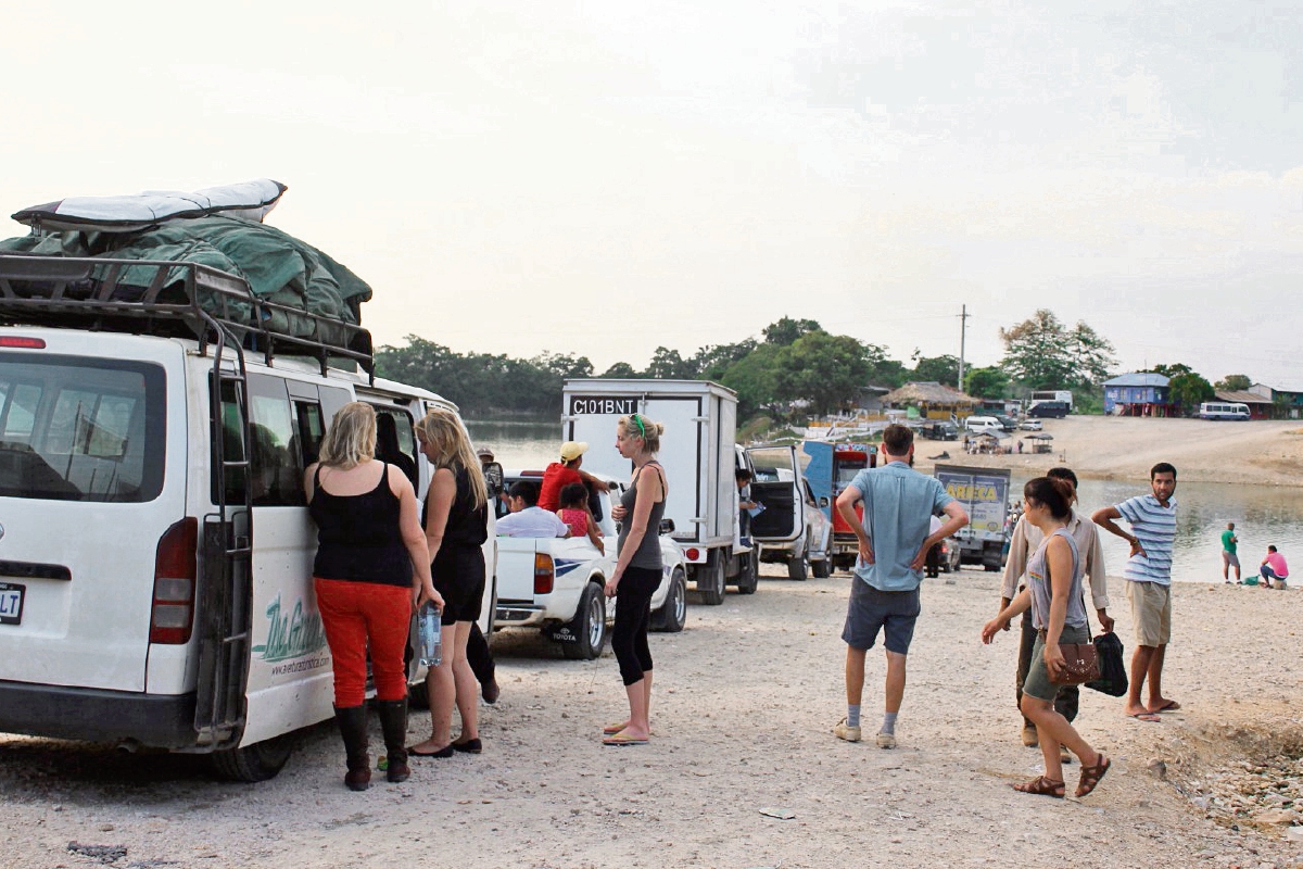 Turistas y  comerciantes deben esperar  hasta seis horas para pasar en vehículo por el transbordador sobre el río La Pasión, en Sayaxché, Petén. (Foto Prensa Libre: Rigoberto Escobar)