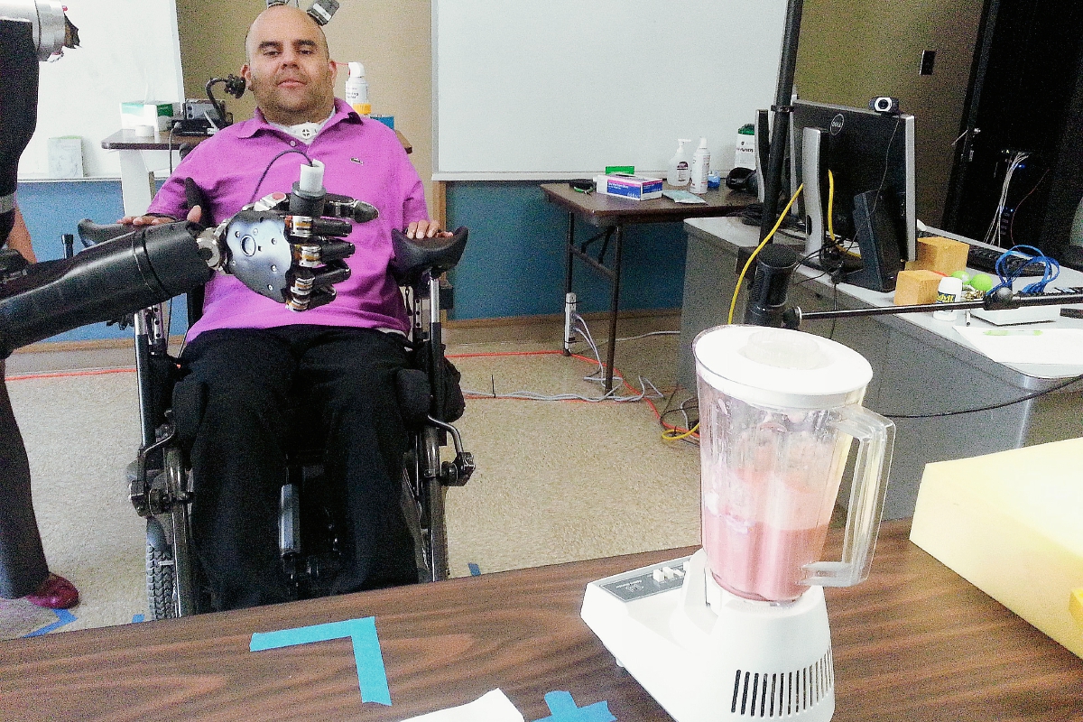 Erik Sorto de 34 años y que sufre parálisis de cuello hacia abajo, ha realizado movimientos como dar la mano con la ayuda del brazo robótico. (Foto Prensa Libre AFP).