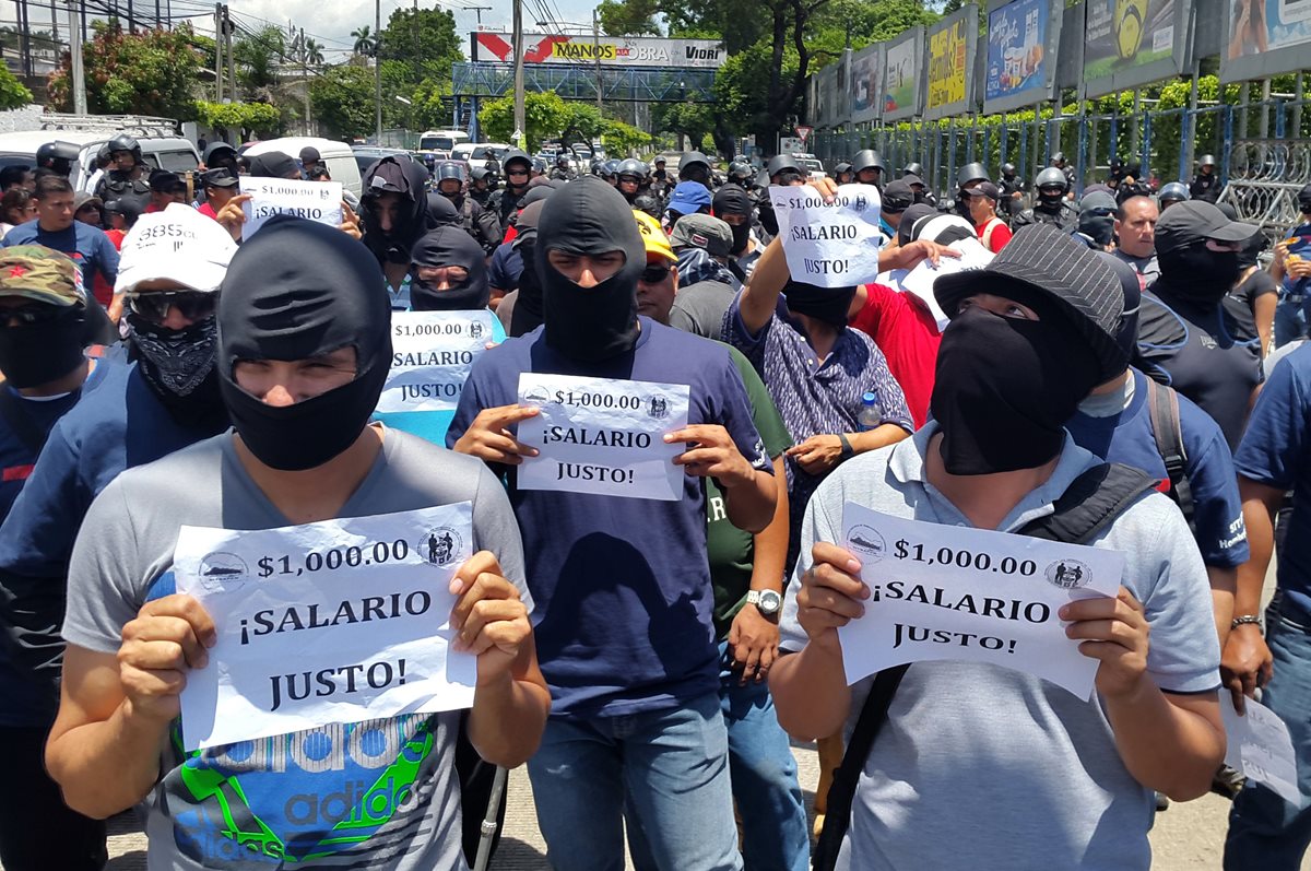 <em>Varios policías salvadoreños portan pancartas para exigir al Gobierno un aumento salarial. (Foto Prensa Libre: AFP).</em>