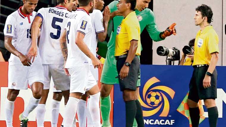 Wálter López recibe los reclamos de los futbolistas costarricenses, en el partido contra los mexicanos. (Foto Prensa Libre: AFP)
