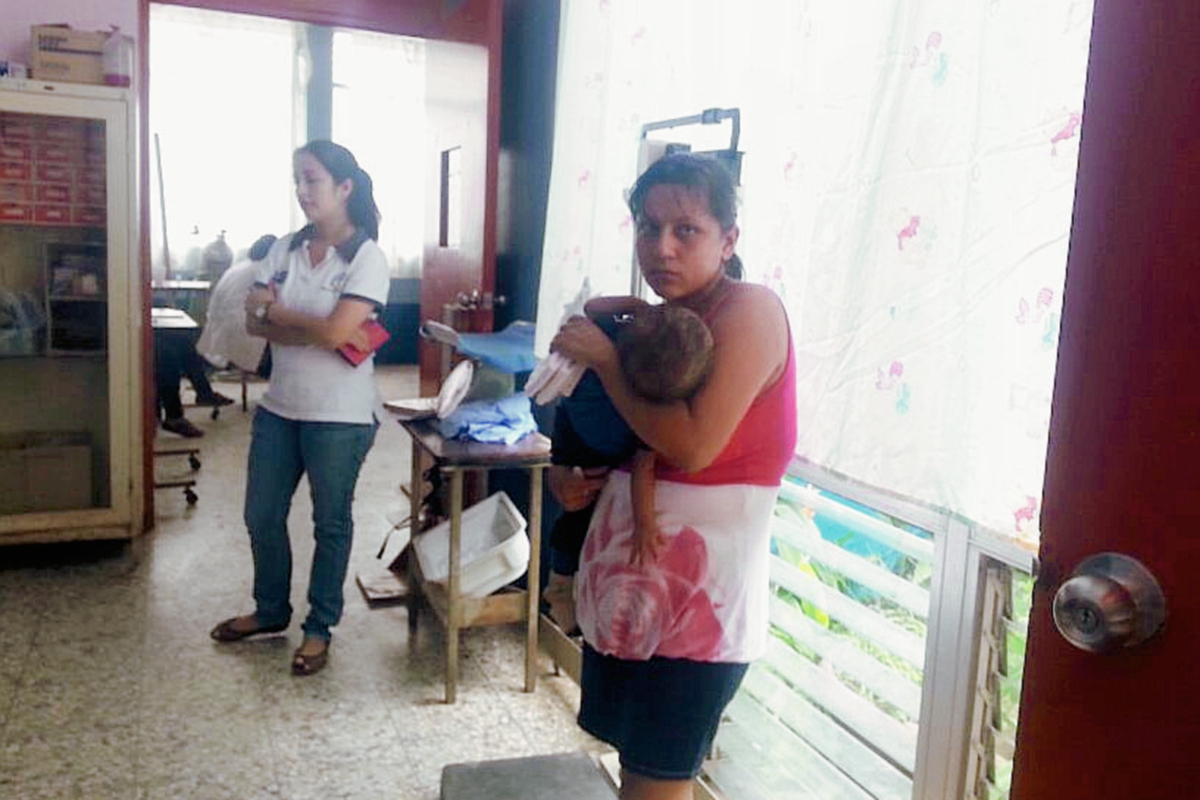 Mujer sostiene a uno de los dos menores que fueron rescatados en Nuevo San Carlos, Retalhuleu. (Foto Prensa Libre: Rolando Miranda)