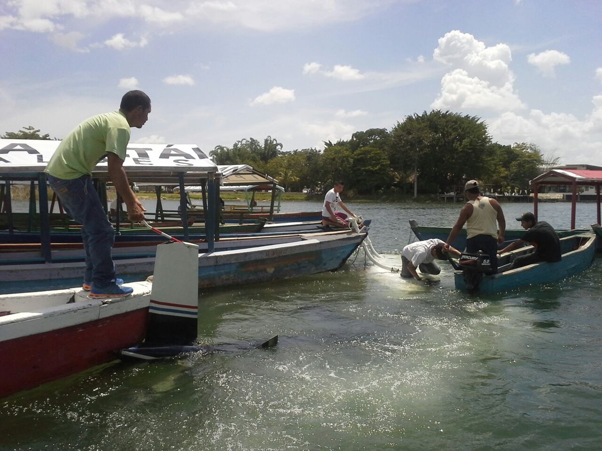 Lancheros que trabajan en el Lago Petén Itzá acuden al lugar donde un helicóptero cayó, en cercanías de un helipuerto en Santa Elena, Flores. (Foto Prensa Libre: Rigoberto Escobar)