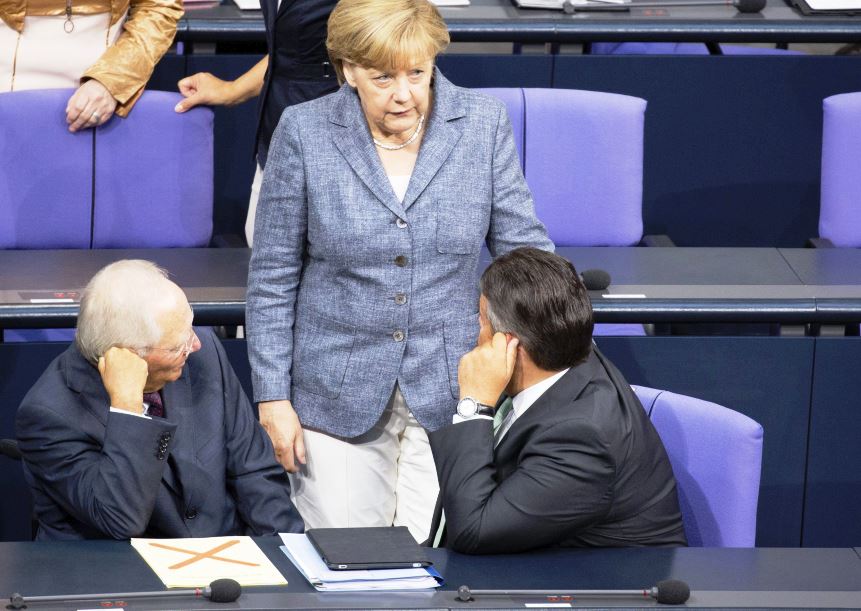 Angela Merkel conversa con los ministros de Finanzas, Wolfgang Schäuble (izq), y de Economía, Sigmar Gabriel, durante el debate y votación del tercer rescate a Grecia. (Foto Prensa Libre: EFE)