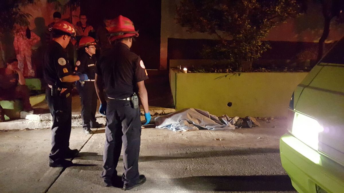 Bomberos Municipales cubren el cuerpo del hombre acribillado en la zona 12. (Foto Prensa Libre: Cortesía)