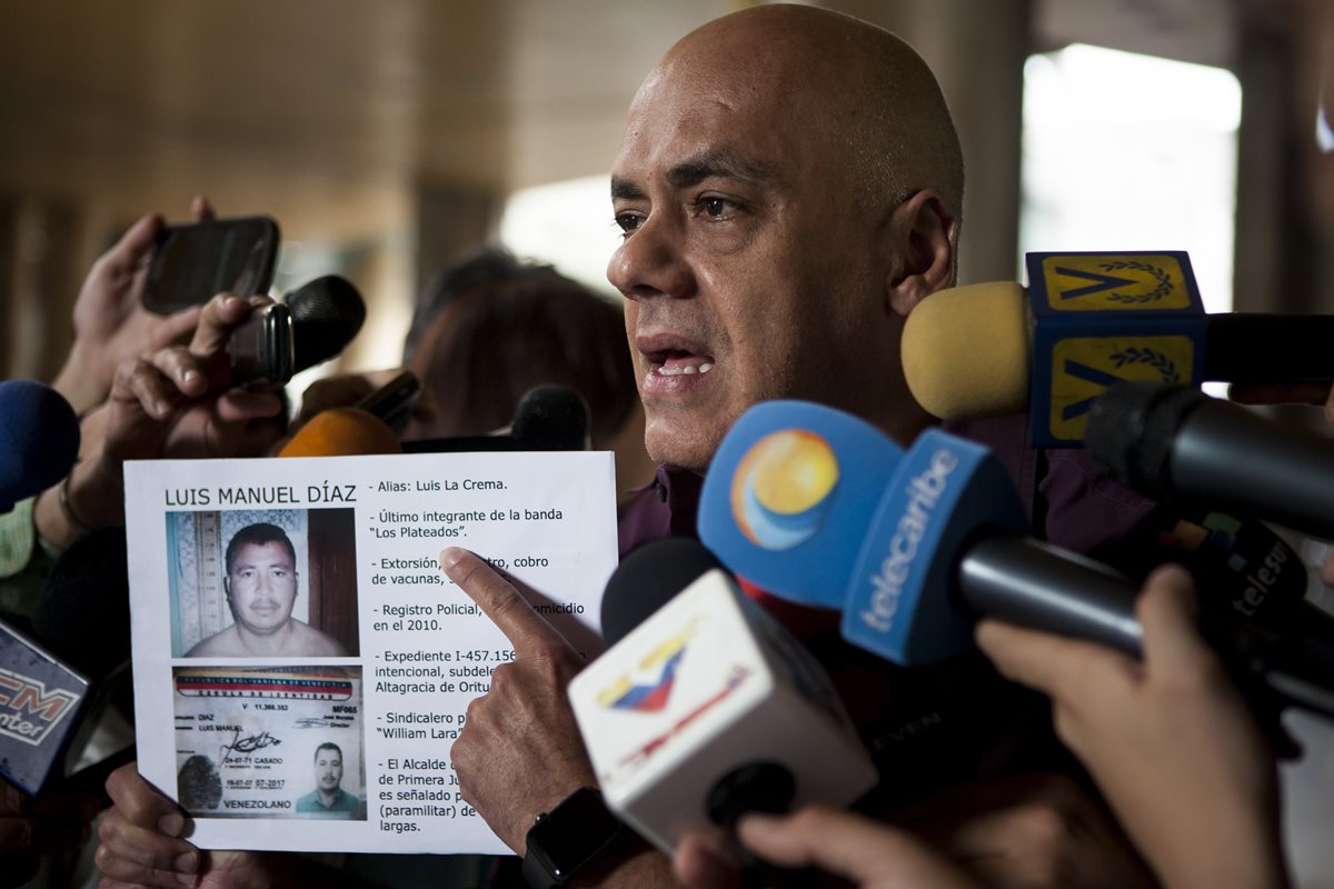 El jefe de campaña del chavismo, Jorge Rodríguez, muestra una imagen del opositor asesinado. (Foto Prensa Libre: EFE).