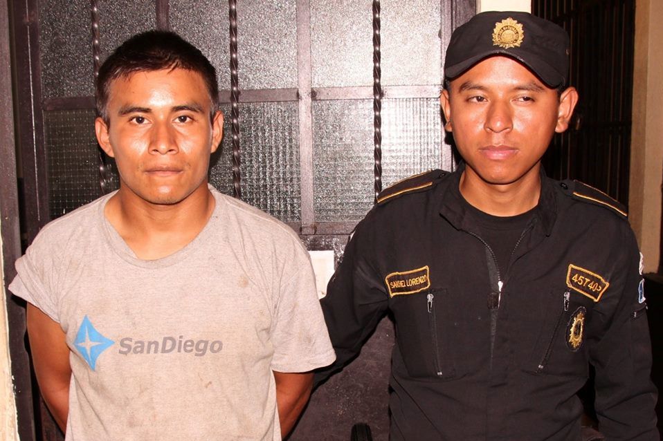 Mario Canteo Iquic es resguardado por un agente de la PNC en Siquinalá, Escuintla. (Foto Prensa Libre: PNC)