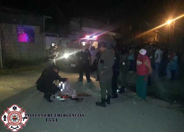 Un agente de la Policía cubre el cadáver del fallecido en la colonia San José. (Foto Prensa Libre: Asonbomd)