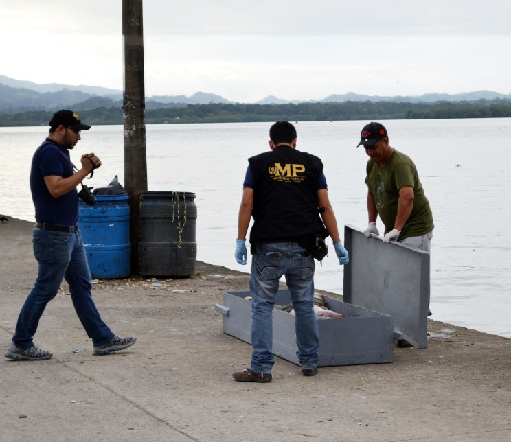 Fiscales del Ministerio Público resguardan el cuerpo de una de las víctimas. (Foto Prensa Libre: Edwin Perdomo)