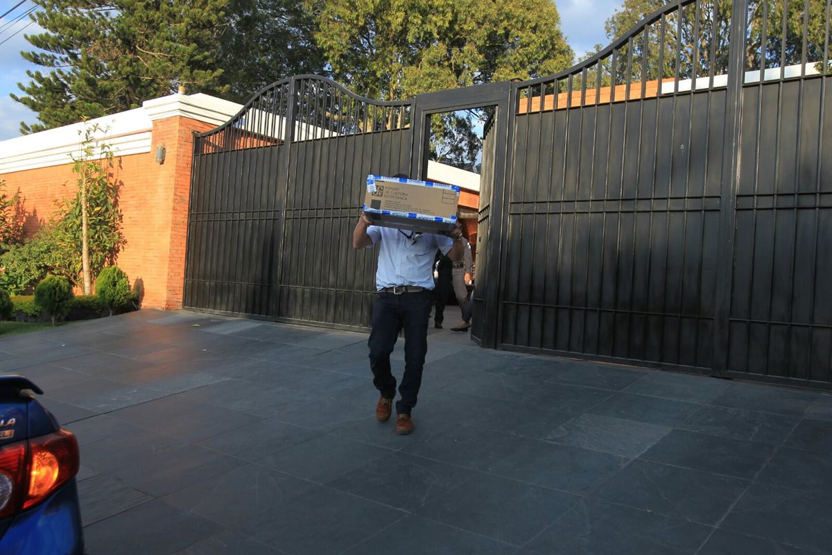 Un fiscal saca documentos incautados en residencia de Pérez Molina en la zona 15. (Foto Prensa Libre: Hemeroteca PL)