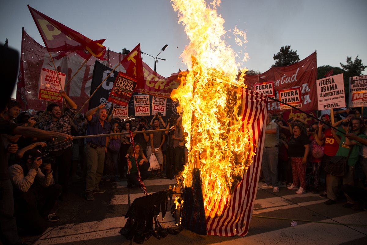 Manifestantes queman una bandera de EE. UU. frente a la embajada de Wasihington en Buenos Aires. (Foto Prensa Libre: AP).