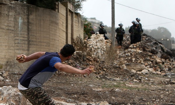 Un joven manifestante palestino lanza piedras hacia las fuerzas israelíes.(AFP).