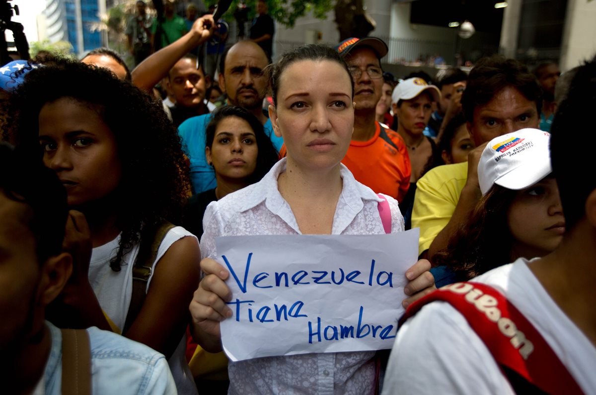 Una mujer porta una pancarta durante las recientes manifestaciones contra las políticas de Nicolás Maduro en Venezuela. (Foto Prensa Libre: AP).