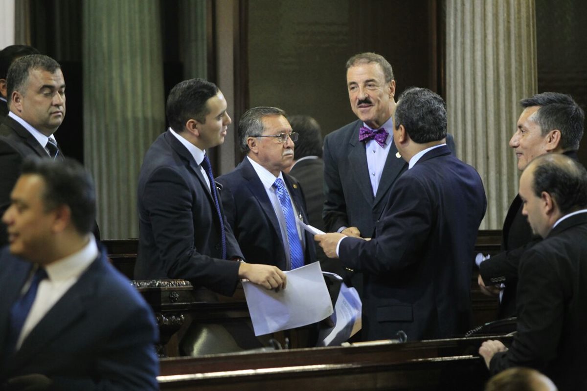 Fernando Linares, de corbatín morado, firmante de la enmienda, conversa con otros diputados durante la sesión de este jueves en el Congreso. (Foto Prensa Libre: Edwin Bercián)