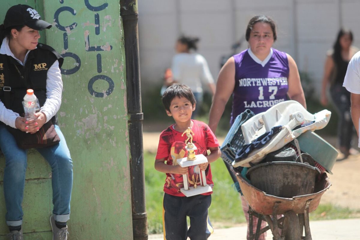 Una madre y su hijo sacan sus pertenencias del área desalojada. (Foto Prensa Libre: Érick Ávila)