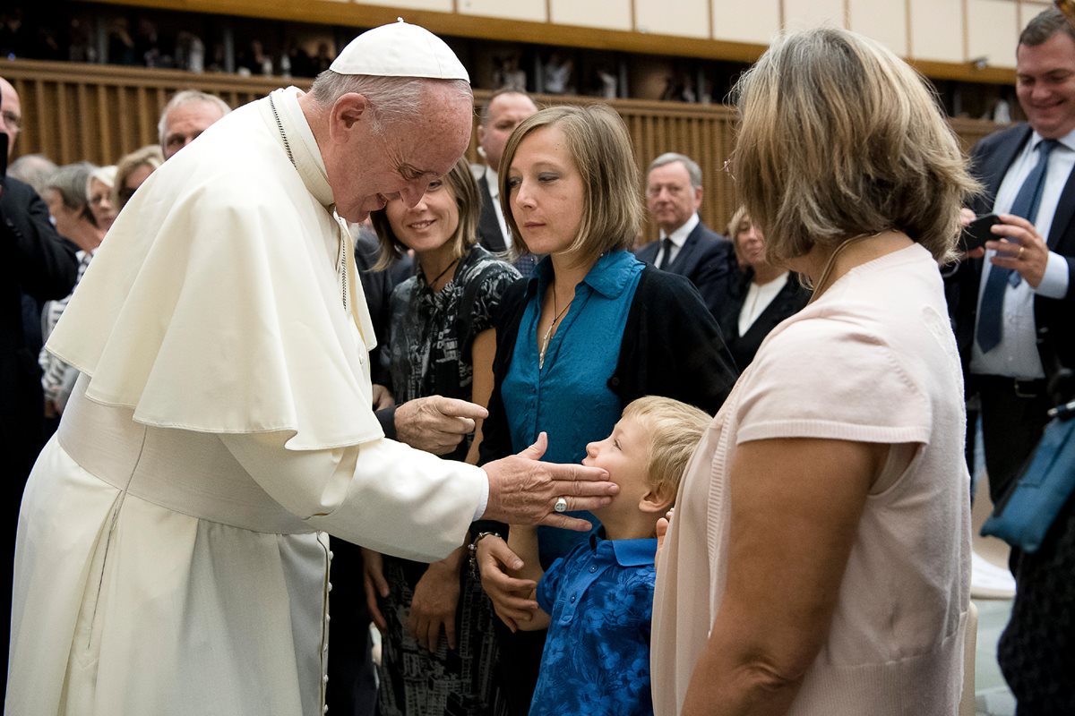 El papa Francisco toca el rostro de un niño, familiar de las víctimas del atentado de Niza. (Foto Prensa Libre: AP).