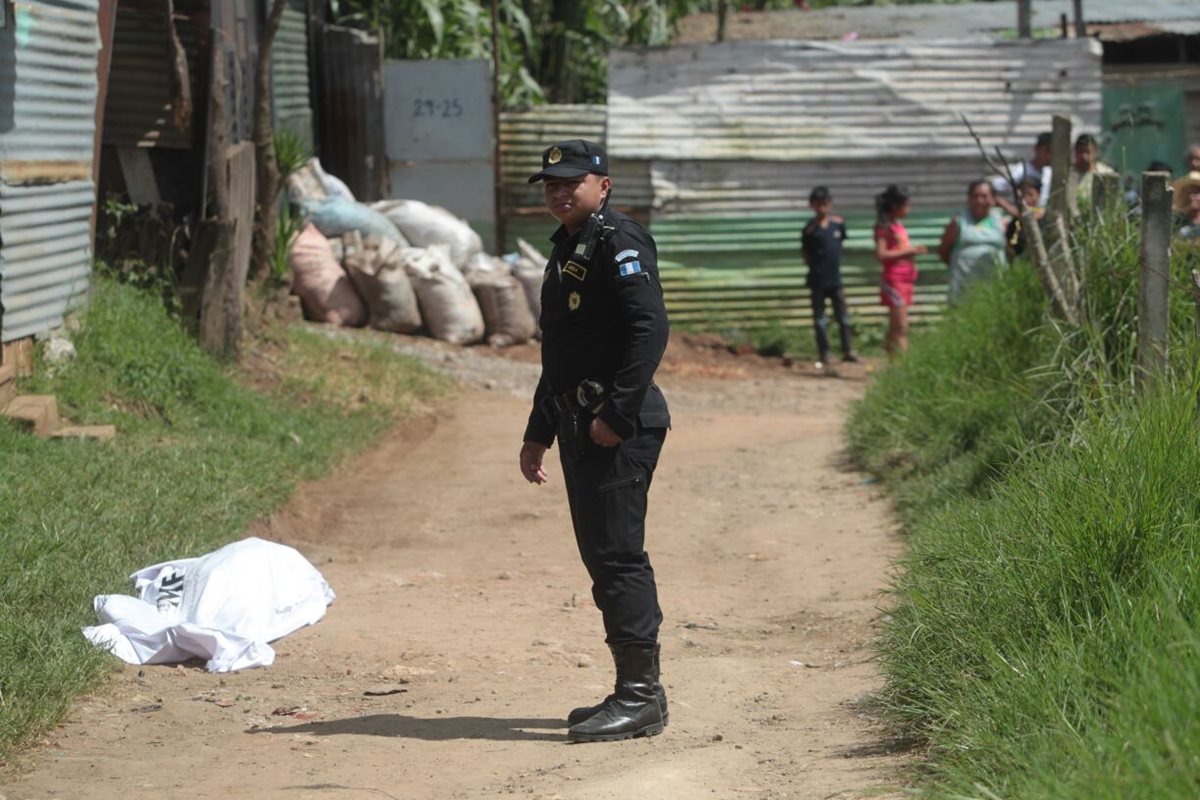 Un agente de la Policía Nacional Civil aguarda la orden para remitir el paquete con los restos humanos a la morgue del Inafic. (Foto Prensa Libre: Erick Ávila)