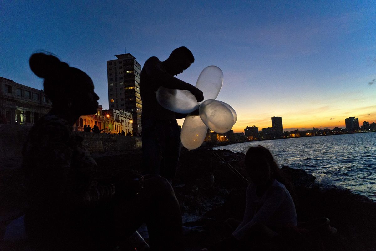 El cubano Junior Torres López une condones inflados para que su línea de pesca mantenga su cebo en el agua y aumente la resistencia contra la atracción de pescado pesado. (Foto Prensa Libre: AP).