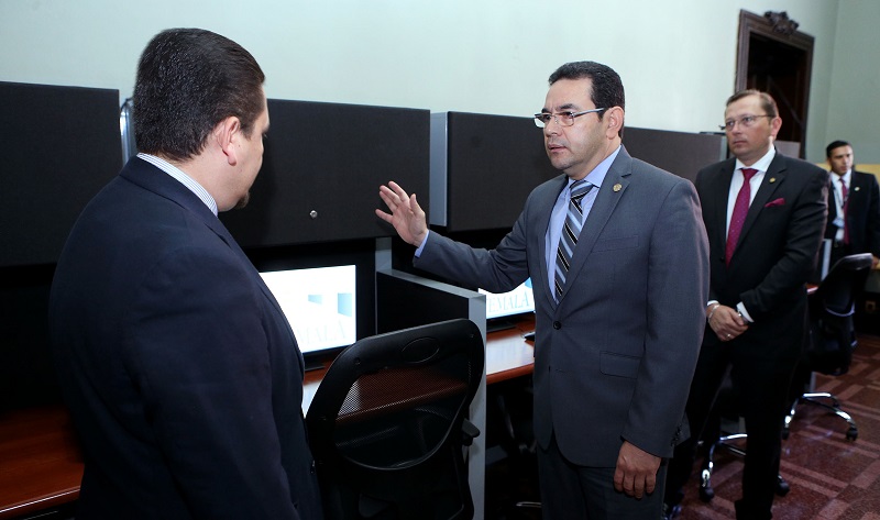 Morales conversa con el secretario de Comunicación, Alfredo Brito, en la remodelada sala de prensa del Palacio. Atrás el vocero presidencial, Heinz Heimann. (Foto Prensa Libre: AGN)