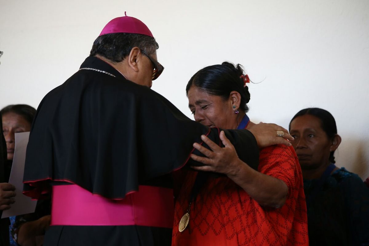 Monseñor Óscar Julio Vian entrega el reconocimiento a una mujer víctima de abusos sexuales durante el conflicto armado interno. (Foto Prensa Libre: Paulo Raquec)