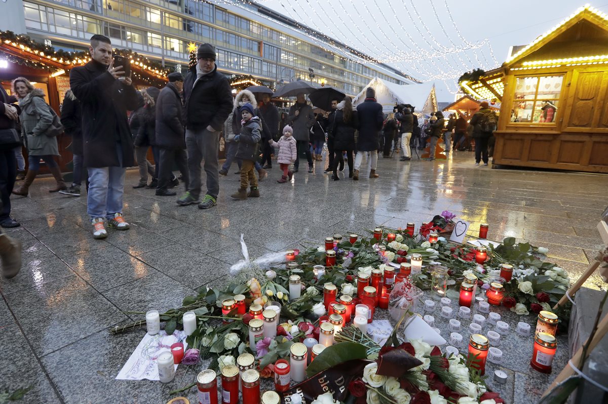 Un mercado navideño en Berlín donde velas, flores y fotografías recuerdan a las víctimas del atentado terrorista del 19 de noviembre último. (Foto Prensa Libre: AP).