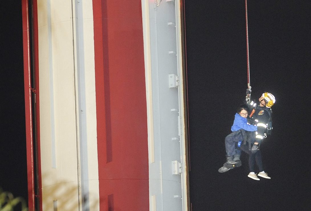 Un socorrista ayuda a descender a una mujer de la atracción. (Foto Prensa Libre: AP).