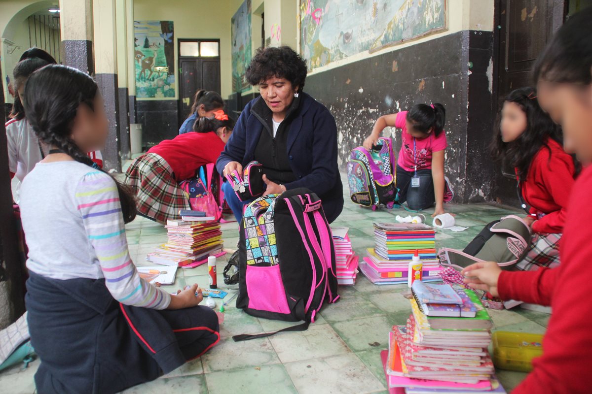 Con la participación de maestros y padres de familia, una comisión de seguridad revisa las mochilas de estudiantes. (Foto Prensa Libre: Mike Castillo)