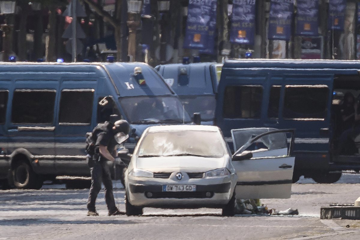 Agentes de policía galos participan en una operación en la céntrica avenida de los Campos Elíseos, donde un carro ha impactado contra un furgón de la Gendarmería francesa. (Foto Prensa Libre: EFE)