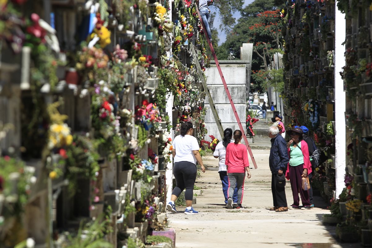 Familias decoran las tumbas de sus seres queridos. Se recomienda evitar colocar flores con agua, para que no proliferen zancudos y mosquitos que transmiten enfermedades. (Foto Prensa Libre: Carlos Hernández)