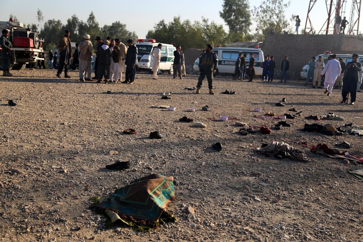 Funcionarios de seguridad inspeccionan la escena de un ataque en el funeral de un exgobernador de distrito en Afganistán. (Foto Prensa Libre: EFE)