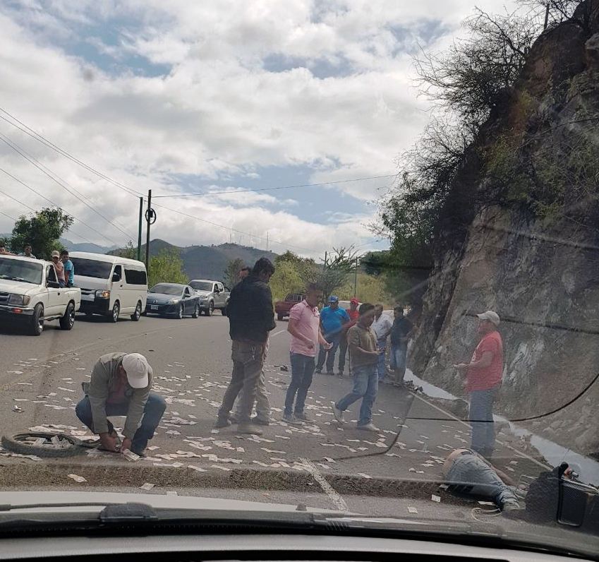 Vecinos del lugar recogieron el dinero del motorista que fue atropellado.(Foto Prensa Libre: Mario Morales)
