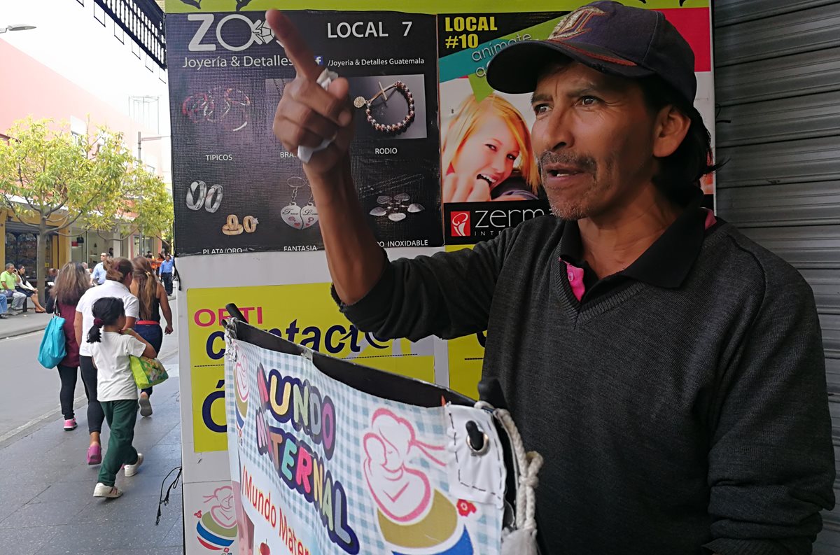 Gustavo Adolfo Juárez Ruiz ofrece ofertas a los visitantes del Paseo de la Sexta, su jornada laboral es de 9 a 16 horas. (Foto Prensa Libre: Edwin Pitán)