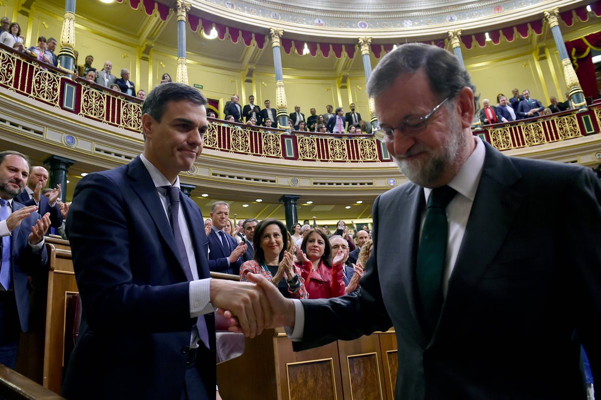 Pedro Sánchez le da un apretón de manos a Mariano Rajoy, luego de cesarlo del cargo. (Foto Prensa Libre: AFP)