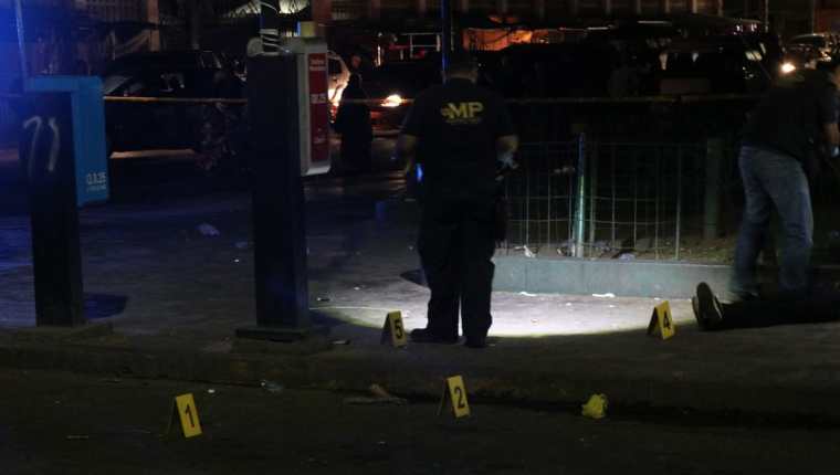 Un investigador del Ministerio Pùblico revisa el área donde un presunto sicario mató a balazos esta noche a una adolescente en el Parque a Benito Juárez. (Foto Prensa Libre: Maria José Longo) 