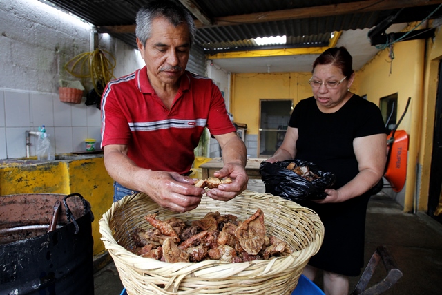 Eligio Castro, junto a su esposa Liliana, muestra la calidad de los chicharrones que prepara. (Foto Prensa Libre: Paulo Raquec)