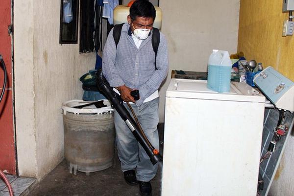 Empleado de Salud fumiga una vivienda en la zona 3 de la ciudad de Retalhuleu. (Foto Prensa Libre: Rolando Miranda) <br _mce_bogus="1"/>