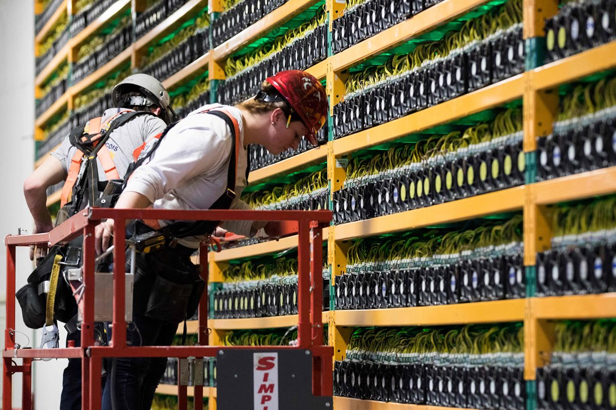 Dos trabajadores de la construcción inspeccionan el área en la compañía minera de bitcoin Bifarms en Saint Hyacinthe, Quebec. (Foto Prensa Libre: AFP)