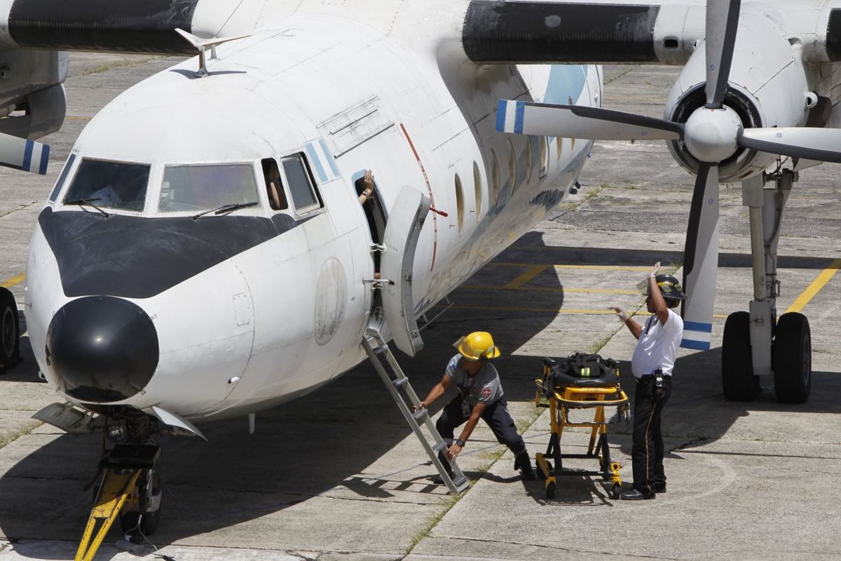 Los cuerpos de socorro sacan a una supuesta víctima del avión, durante el simulacro de secuestro aéreo en el Aeropuerto Internacional La Aurora.