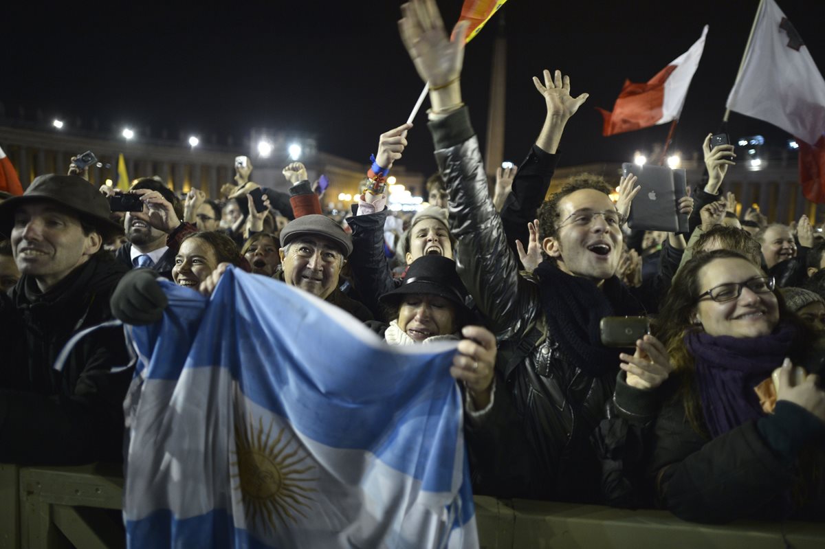 Fieles agitan banderas de Argentina tras escuchar el anuncio de la elección del cardenal argentino Jorge Bergoglio como nuevo Papa. (Foto: AFP)